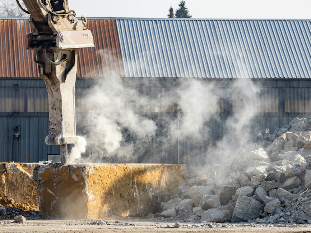 Hydraulic breaker hammering through a concrete slab